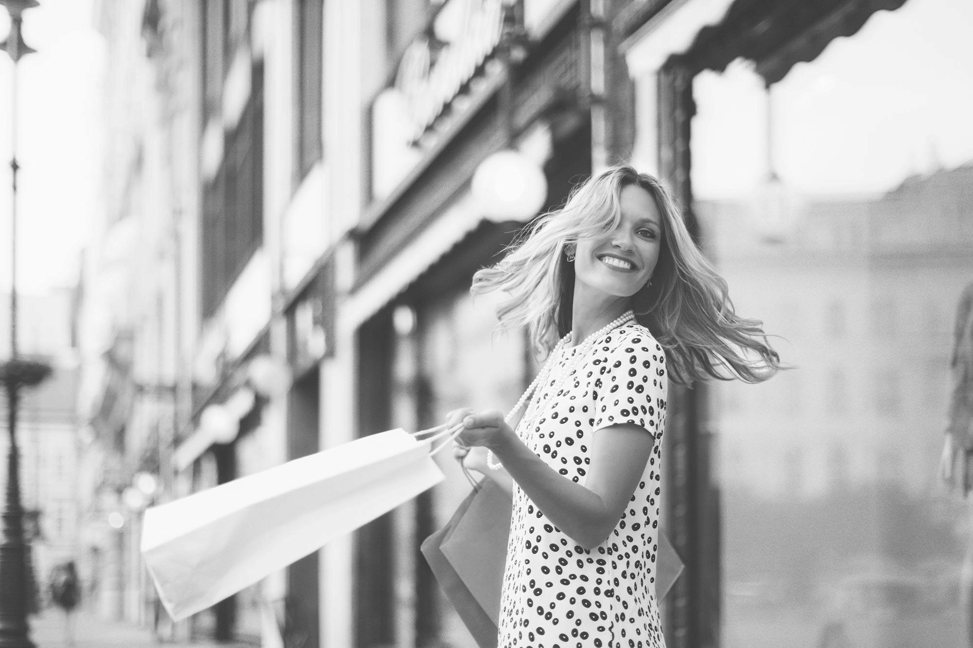 woman happily shopping in an outdoor retail mall